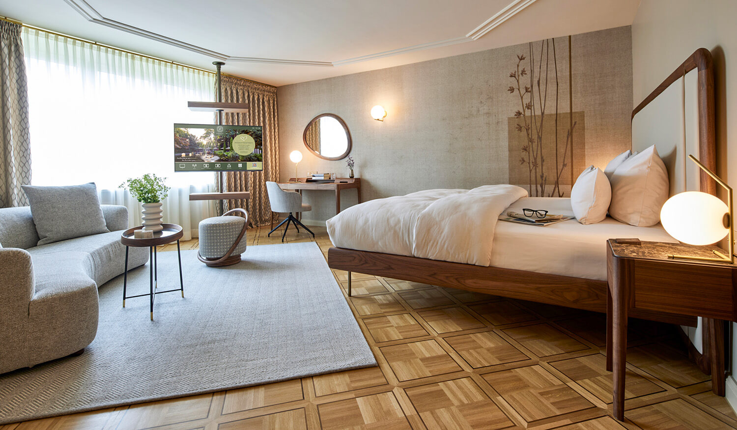 Elegantes Hotelzimmer mit hochwertigem Parkettboden, modernem Bett, gemütlicher Sitzecke und Schreibtisch für eine einladende und luxuriöse Atmosphäre