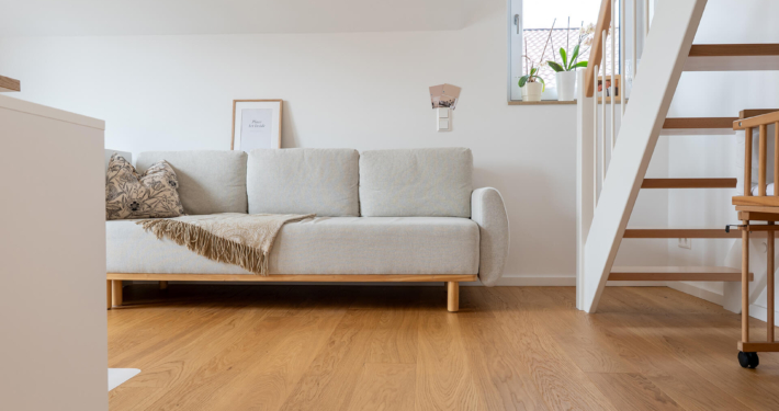 Wohnzimmer mit Comfort Tabis Diele Grande Eiche Standard bei Aschaffenburg Wohnzimmer mit geölter Comfort Tabis Diele Grande sowie modernen Einrichtungsgegenständen und einer hellen Couch
