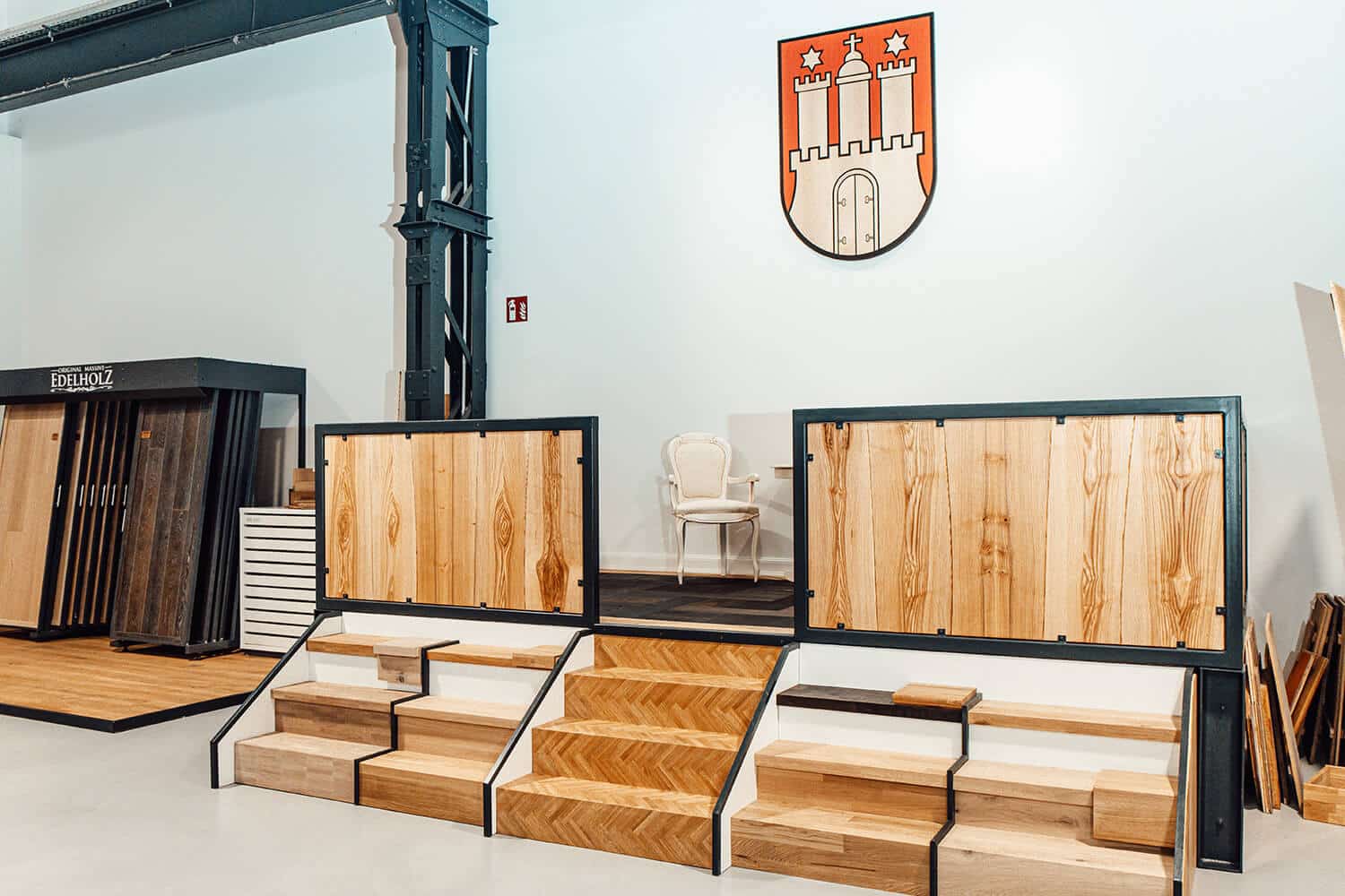 parkett-ausstellung-hamburg-bembe-musterauswahl Bembe Parkett Showroom in Hamburg mit verschiedenen Parkettboden-Mustern, Holzdielen und Verlegemustern in modernen Ausstellungsrahmen unter dem Hamburger Wappen