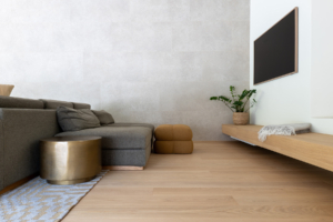 Großzügiges Wohnzimmer mit Fernseher und Sofa. Große Eichendielen auf dem Fußboden.