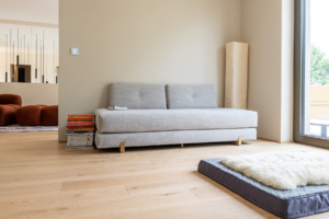 Nebenzimmer mit gemütlicher Couch und Premium Dielenparkett.