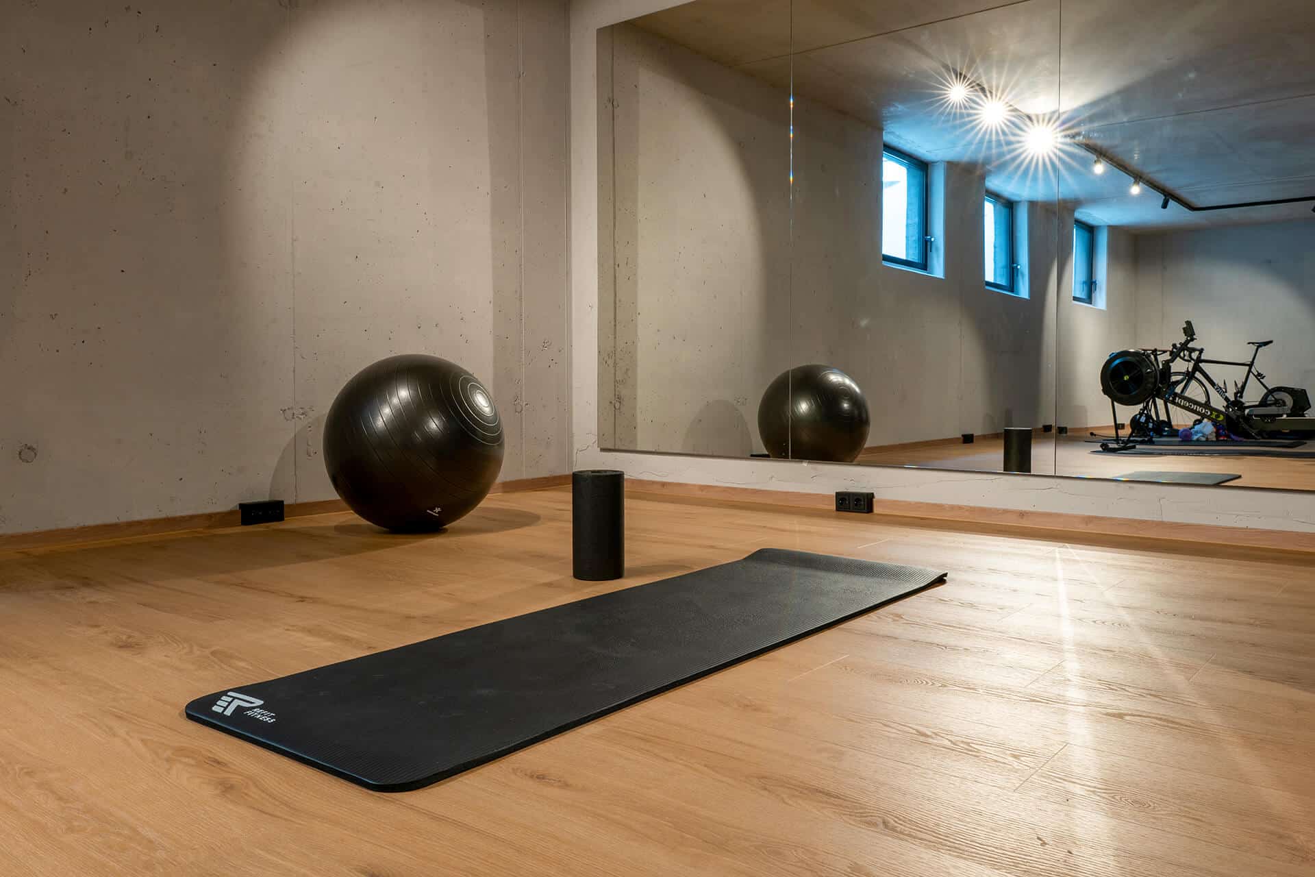designboden-ebenbild-taunus-referenz-mainz Designboden Ebenbild Taunus im Home-Gym mit Spiegelwand, Gymnastikball und Sichtbetonwänden